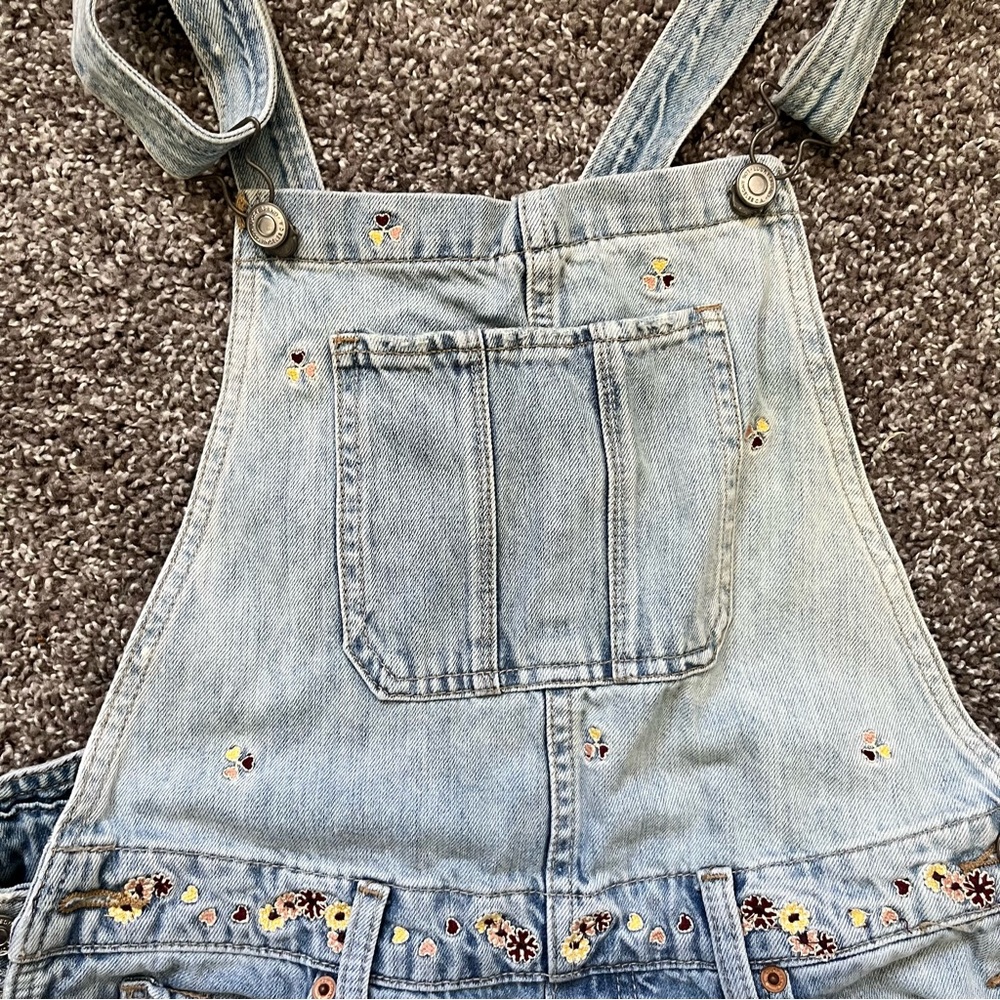 Light wash denim overalls with embroidered details. Size medium